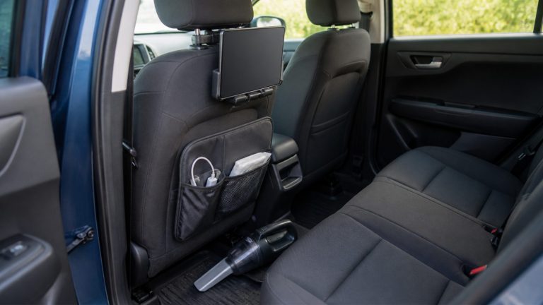 Organized parked car interior with backseat tablet mount and compact vacuum